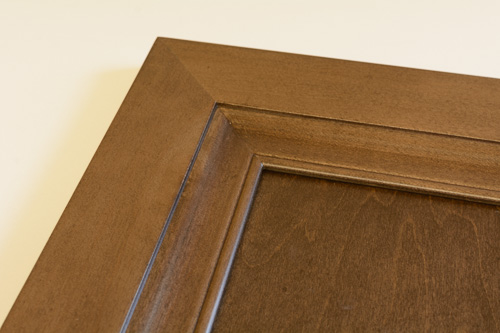 closeup of corner of Anita cabinet door finished in Heritage Walnut (brown tone) stain